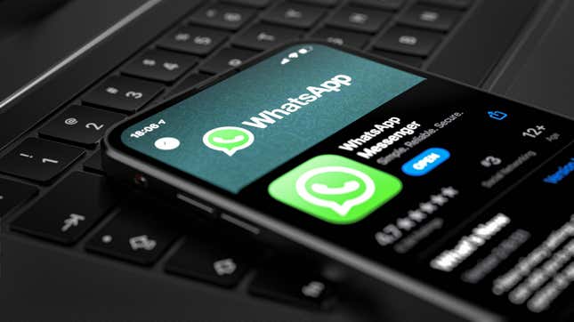 Un teléfono que muestra la aplicación WhatsApp en una computadora portátil